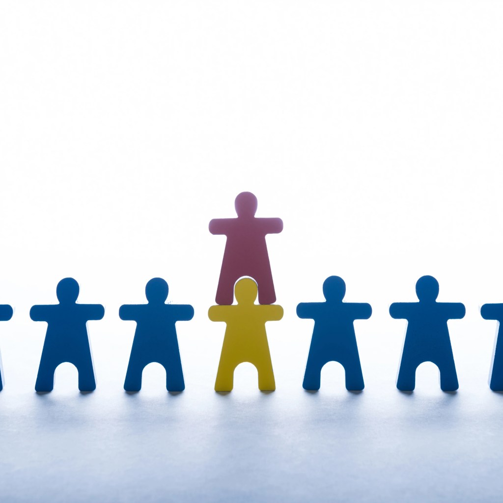 Different colored wooden figures representing unique personality types in mental health